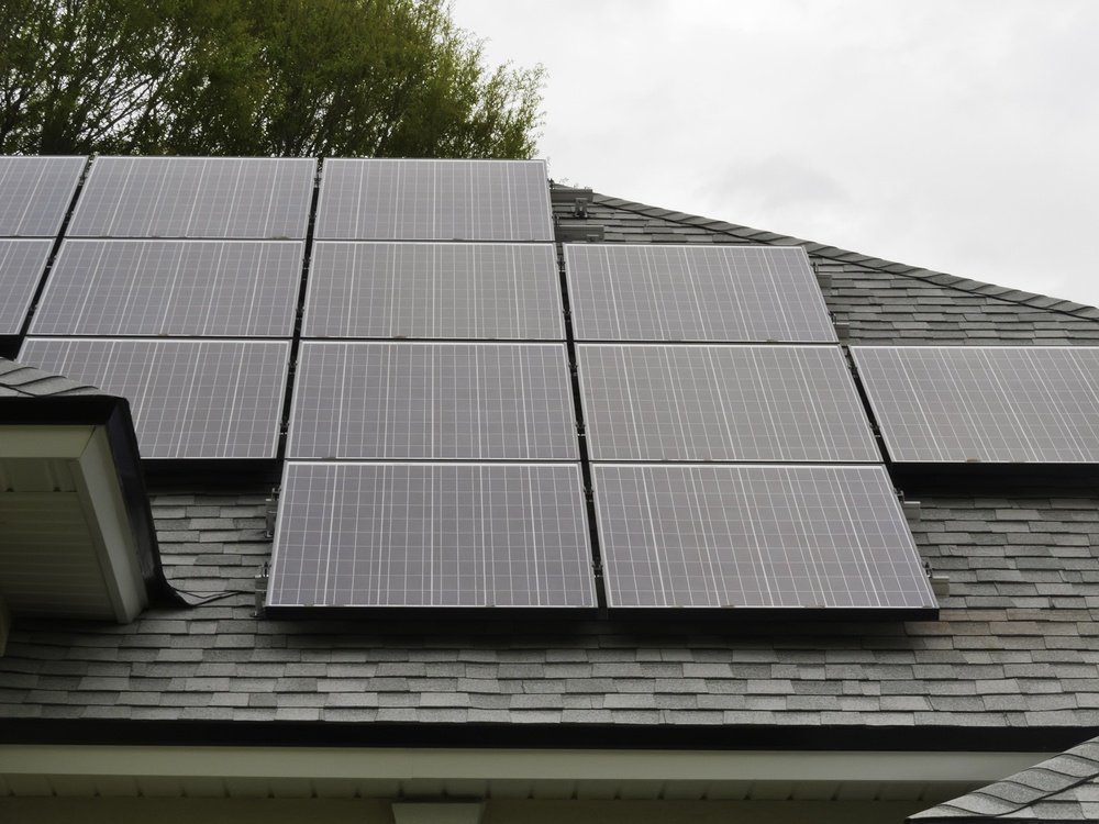 Solar panels on sloped roof of house on overcast day