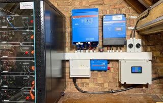 A large off-grid battery system with Victron Quattro 8000 centre, a Victron solar charge controller right, and 6 Pylontech US3000 batteries left